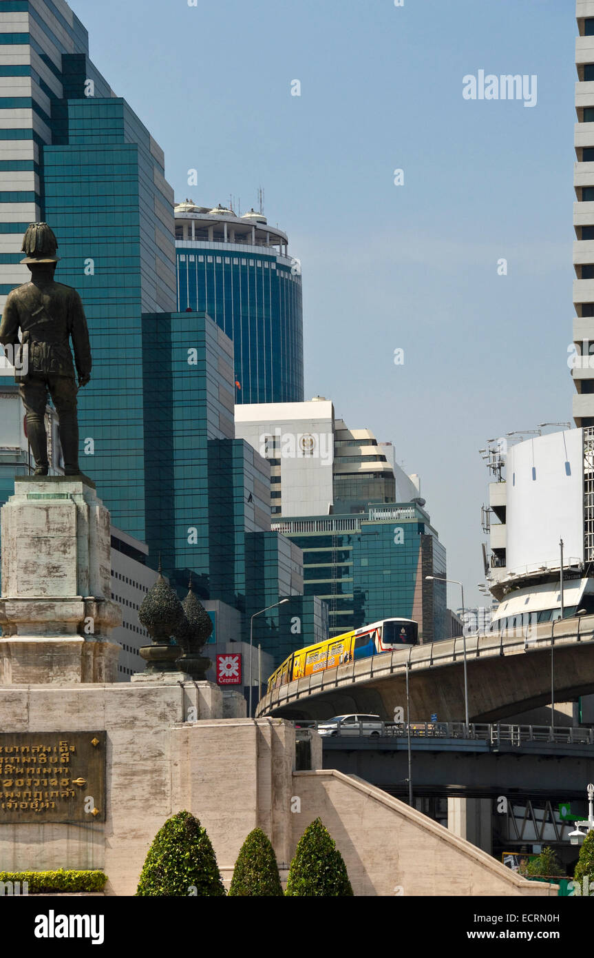 Vertical cityscape of a KIng Rama VI statue looking down Silom Road in Bangkok. Stock Photo
