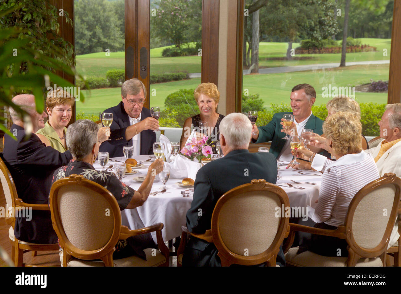 Group of senior citizens dining at country club. Stock Photo