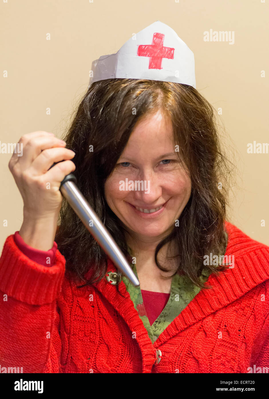 Woman with turkey baster and homemade nurses hat. Stock Photo