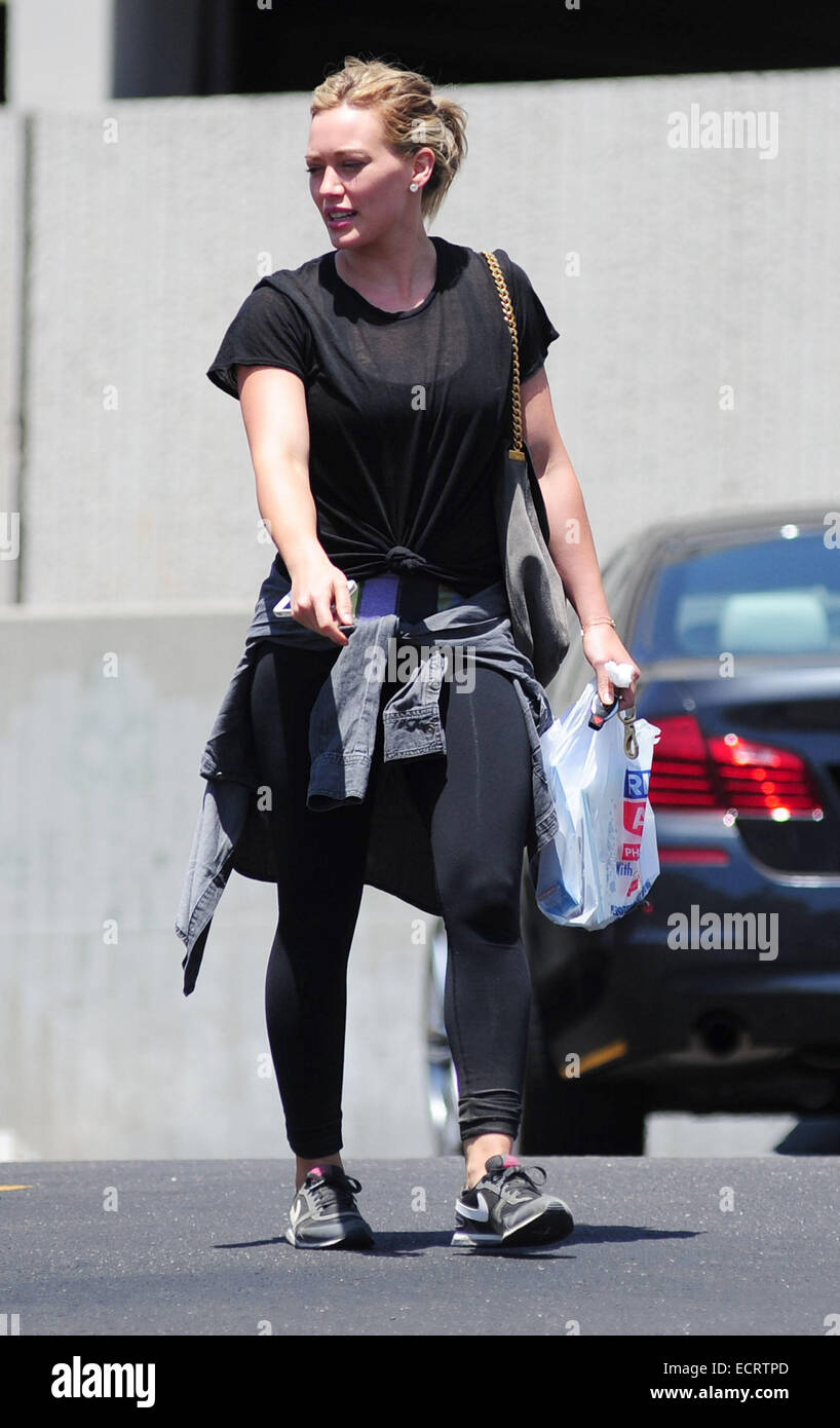 Hilary Duff wearing black sportswear grey sweater tied round her waist and about