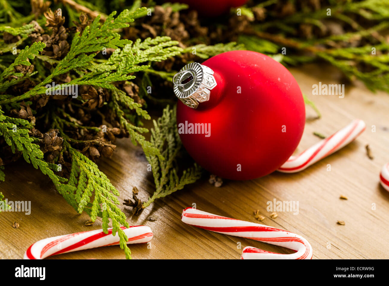 Red Christmas ornaments on stained wood table. Stock Photo