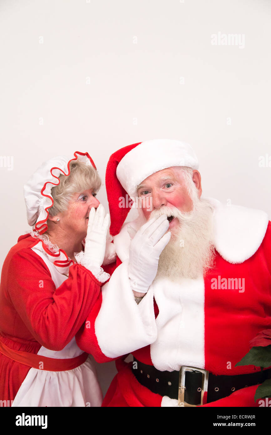 Mrs Claus whispers a secret into Santa's ear Stock Photo - Alamy