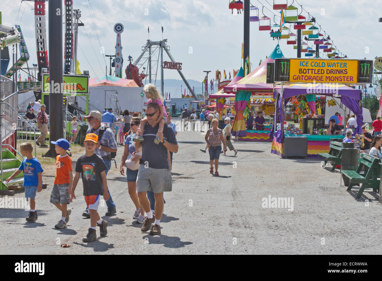 Adults and children explore the colorful state fair rides and food Stock Photo