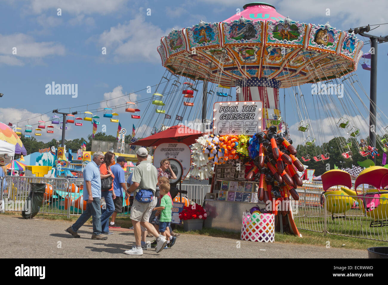 People enjoying the colorful games and rides at the state fair Stock Photo