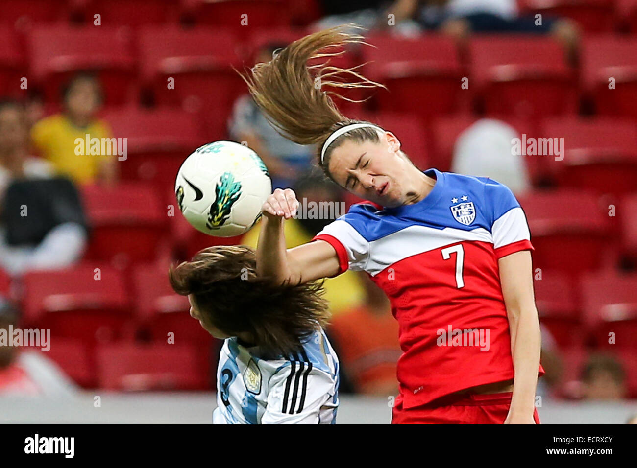 Brasilia, Brazil. 18th Dec, 2014. U.S. player Morgan Brian (R) heads for the ball with Argentina's Noelia Espindola during a match between the U.S. and Argentina of the 2014 International Tournament of Brasilia in Brasilia, capital of Brazil, Dec. 18, 2014. The U.S. won 7-0. © Xu Zijian/Xinhua/Alamy Live News Stock Photo