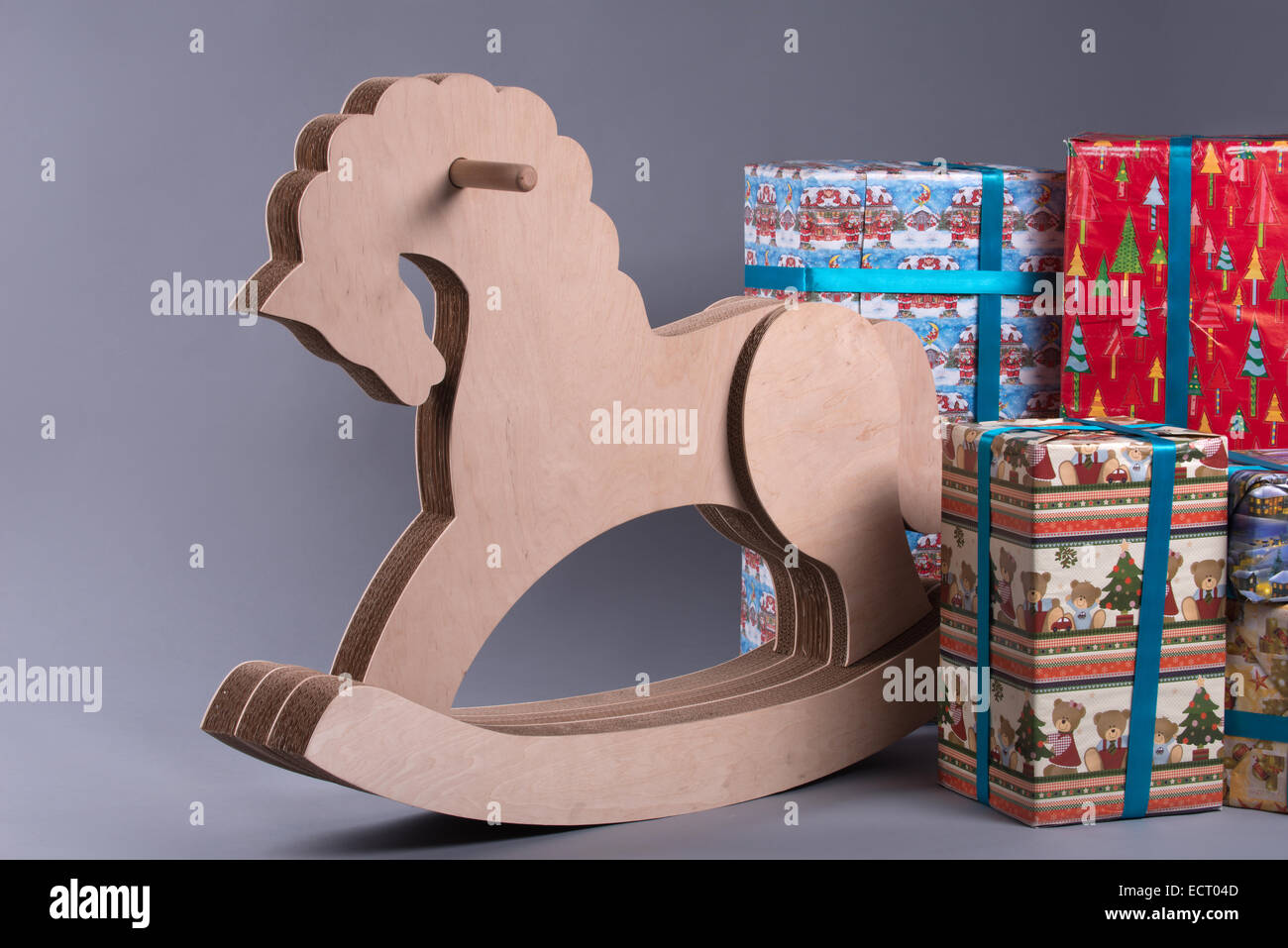 Little wooden toy horse standing near the heap of Christmas presents