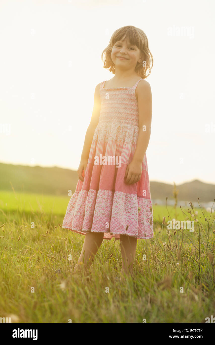 Portrait of little girl wearing summer dress standing on a meadow in