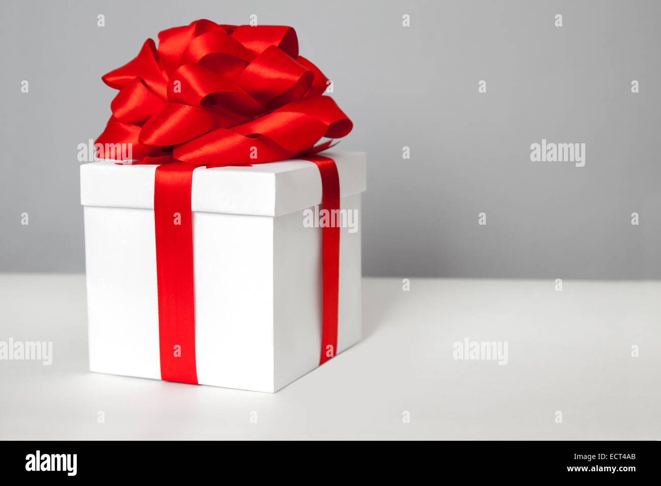 White gift box with red ribbon bow Stock Photo - Alamy