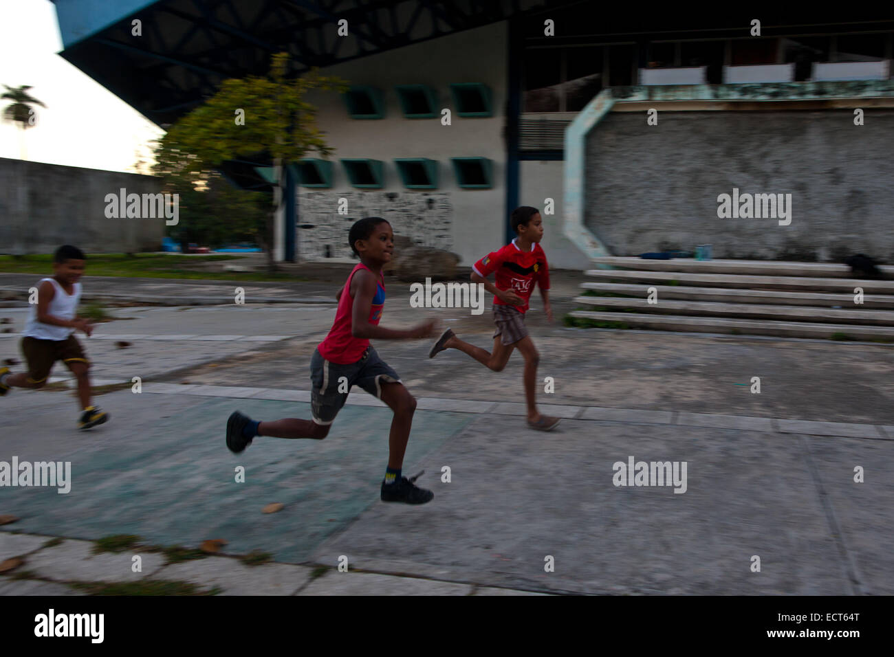 Havana, Cuba. 18th Dec, 2014. Children wearing leisure shoes practice sprint running on the non-sport purpose concrete ground, in Havana, Cuba, on Dec. 18, 2014. After the declaration of restoring diplomatic relations between Cuba and the U.S. from both presidents, local Cubans demand the abortion of blockage from Washington. © Liu Bin/Xinhua/Alamy Live News Stock Photo