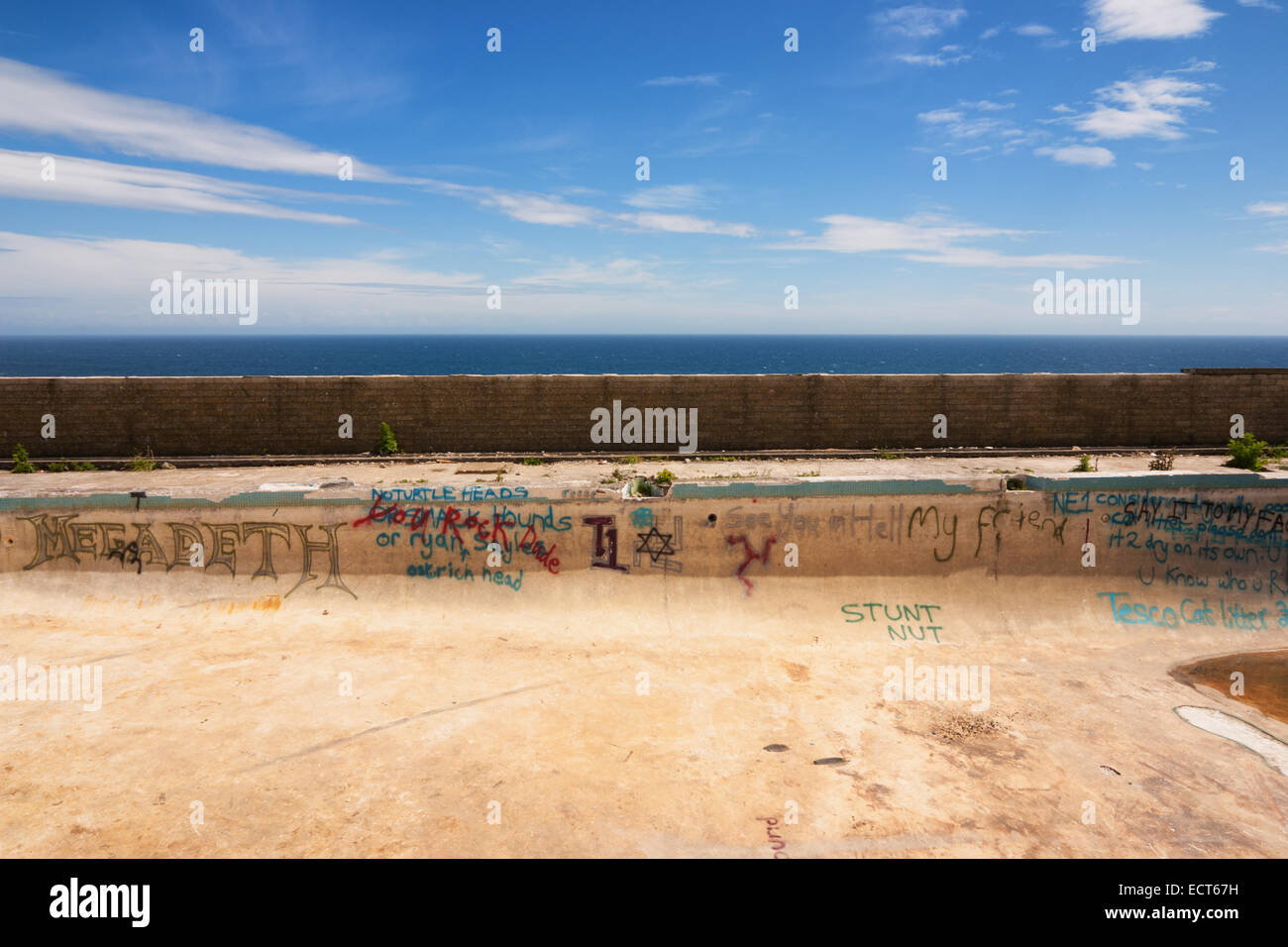 Isle of Man - former swimming pool at an abandoned holiday camp by the sea is now a hang-out for skateboarders. Stock Photo
