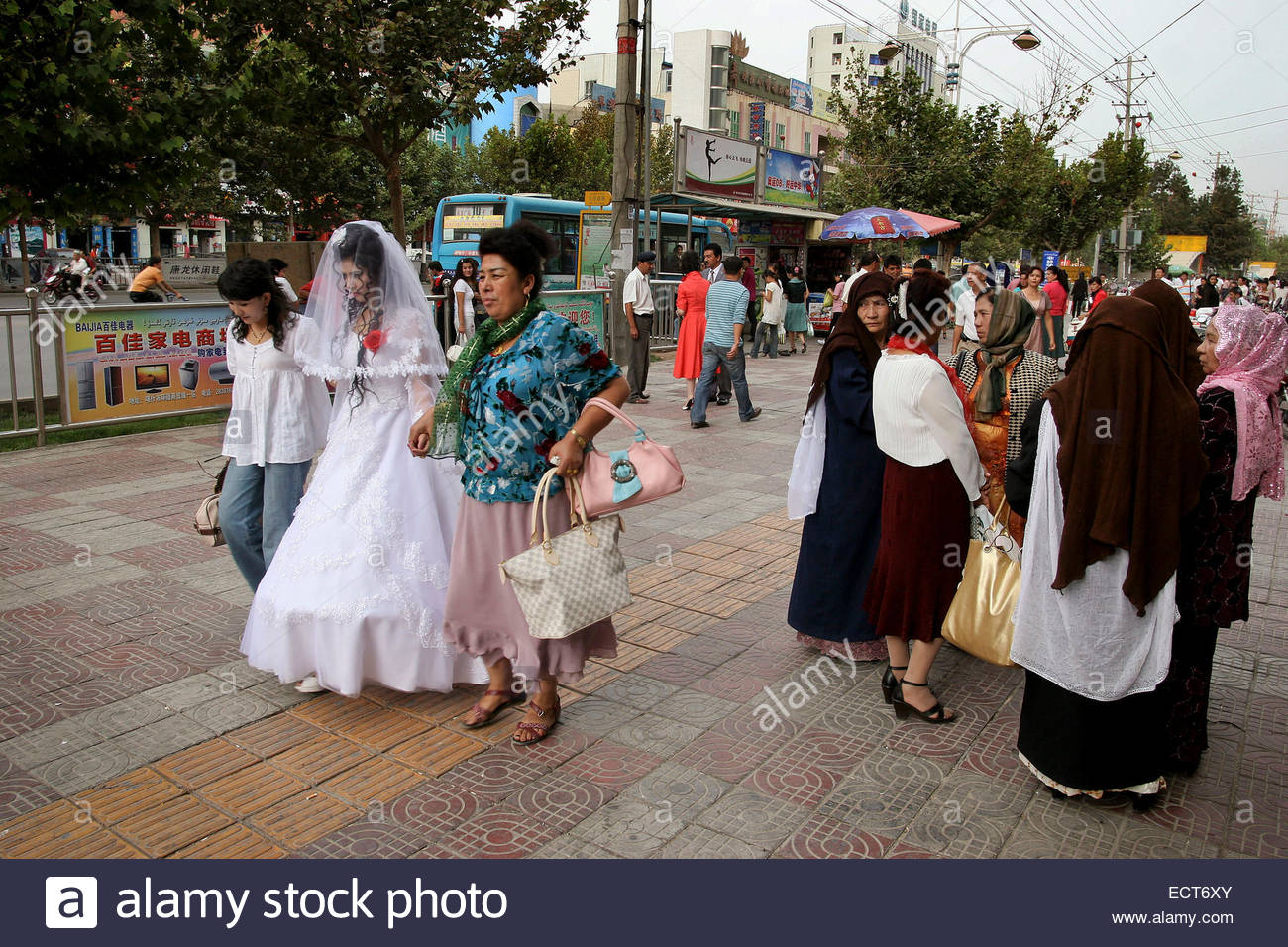 Uyghur Women Watch Passing Chinese Han Bride And Her Mother Stock