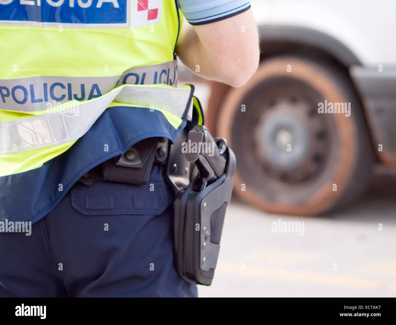 police officer in hi-visibility jacket control traffic, back view Stock Photo