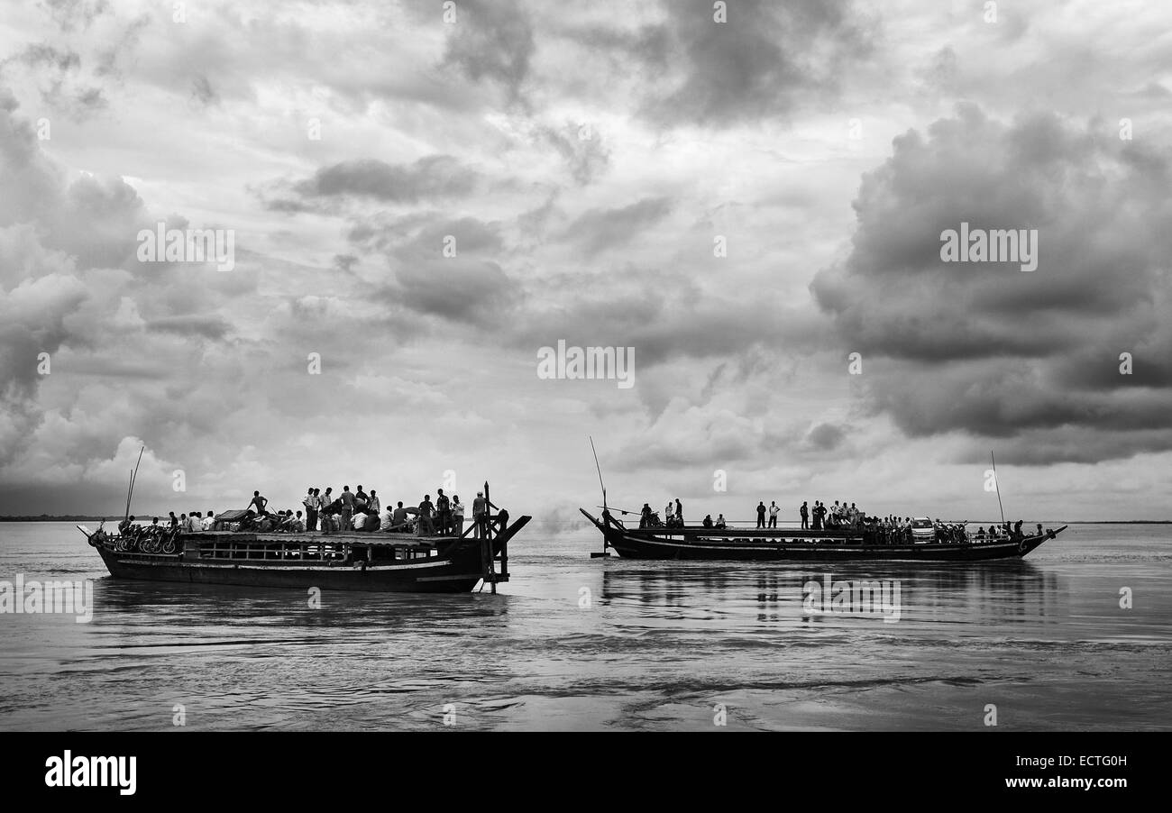 Public ferries cross the Brahmaputra river crowed with passengers leaving for and returning from Majuli island to Jorhat, India. Stock Photo