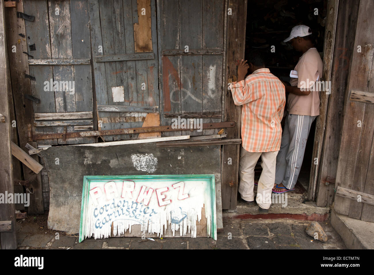 Mauritius, Mahebourg, men in doorway of shoe repair and upholsterer’s shop Stock Photo