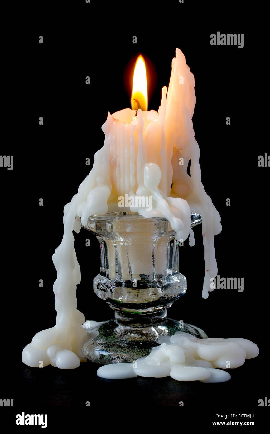 Burning candle in glass candlestick on a black background Stock Photo
