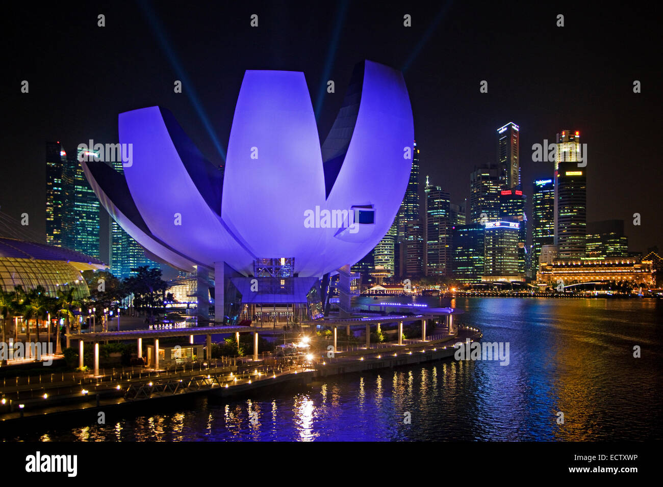 The purple illuminated ArtScience Museum and skyline with skyscrapers and high-rise buildings in Singapore at night Stock Photo