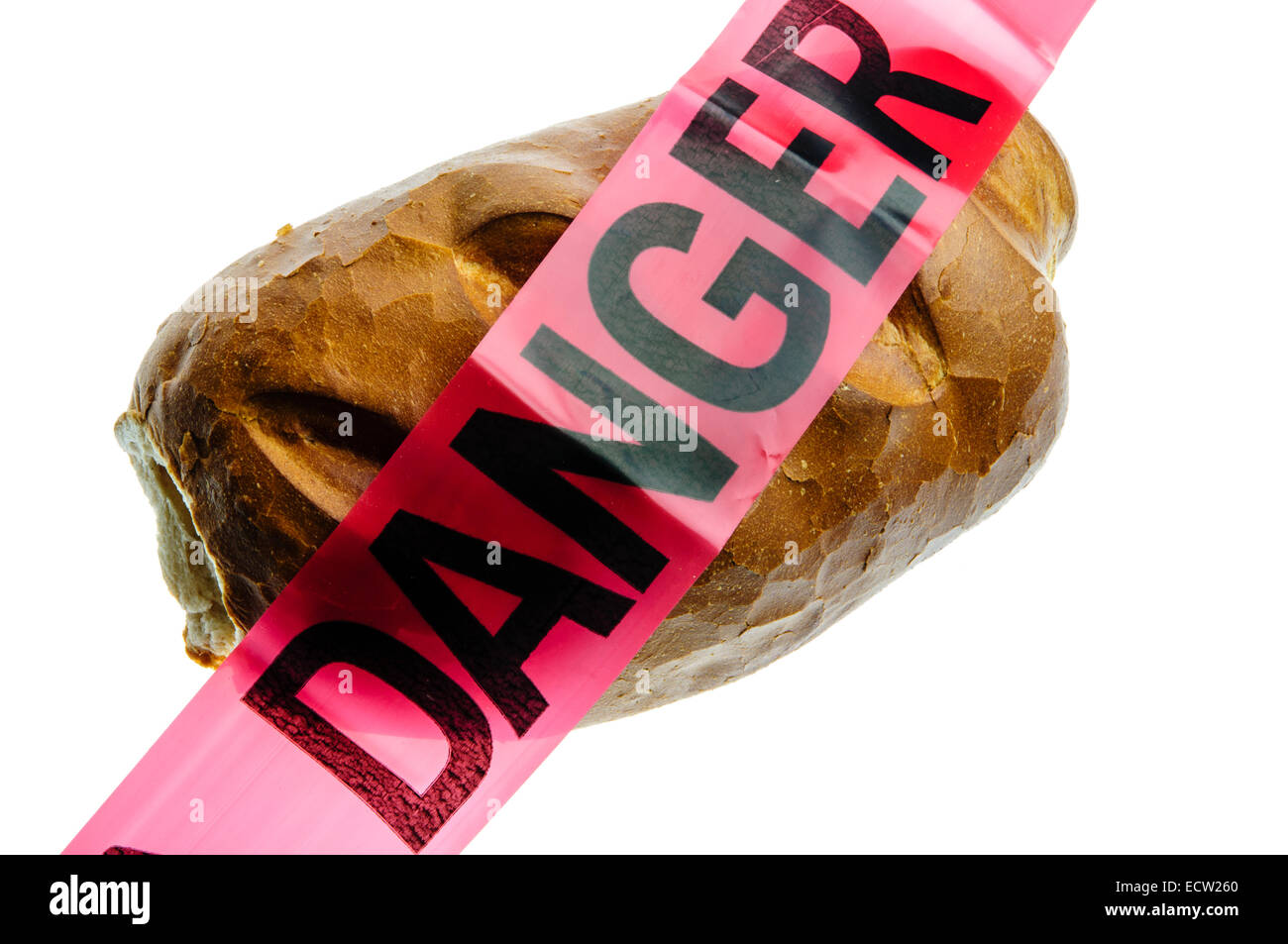 Danger tape placed over crusty bread, to signify the danger of gluten to people with coeliac disease Stock Photo