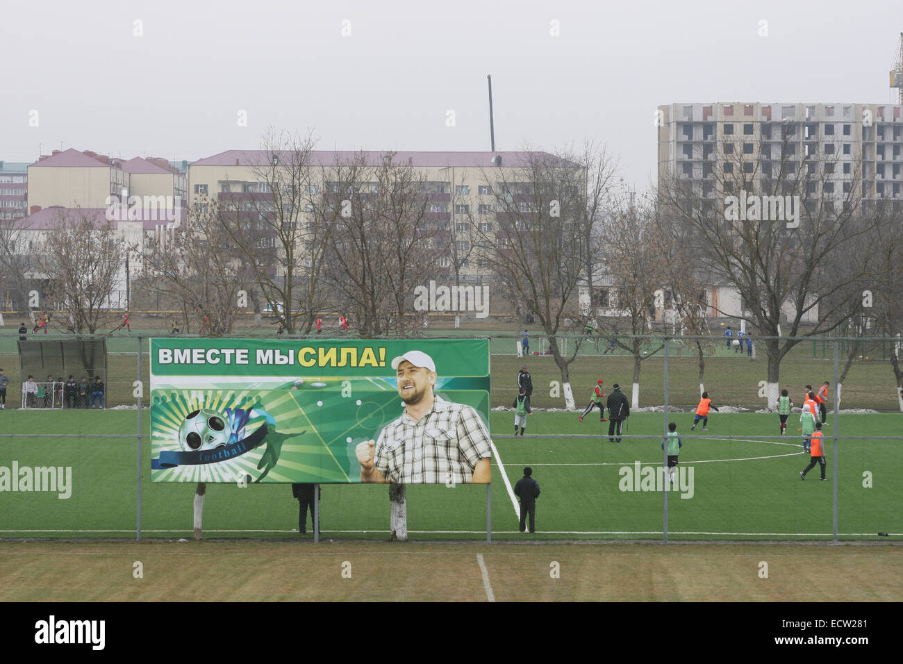 Young football players during training at the Football Academy in the Chechen capital Grozny, Russia. The billboard with president Ramzan Kadyrov says:' Together we are a force'. Stock Photo