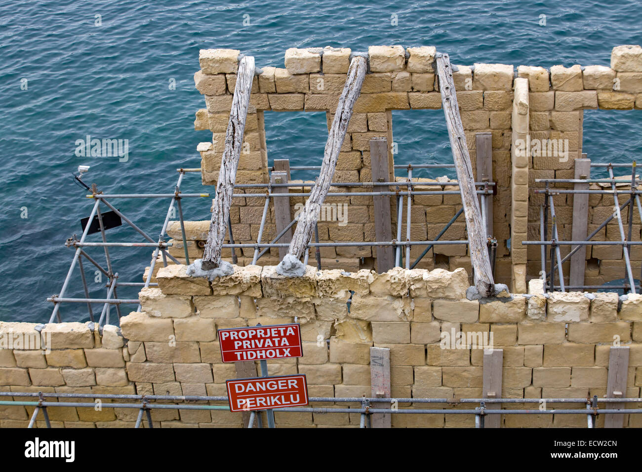 Scaffolding on a stone structure over the ocean Stock Photo