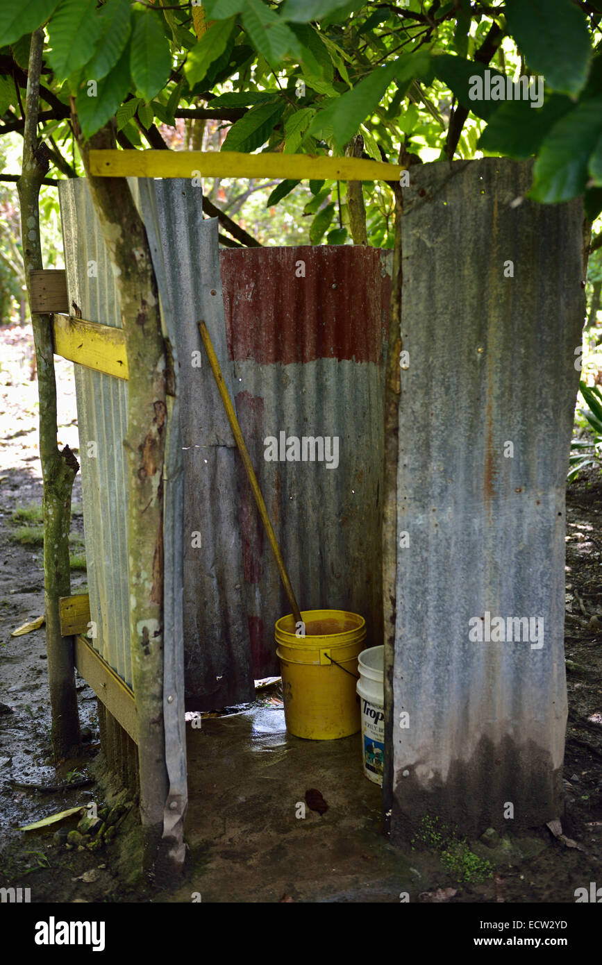 Simple corrugated tin walls of outdoor squat latrine toilet with bucket