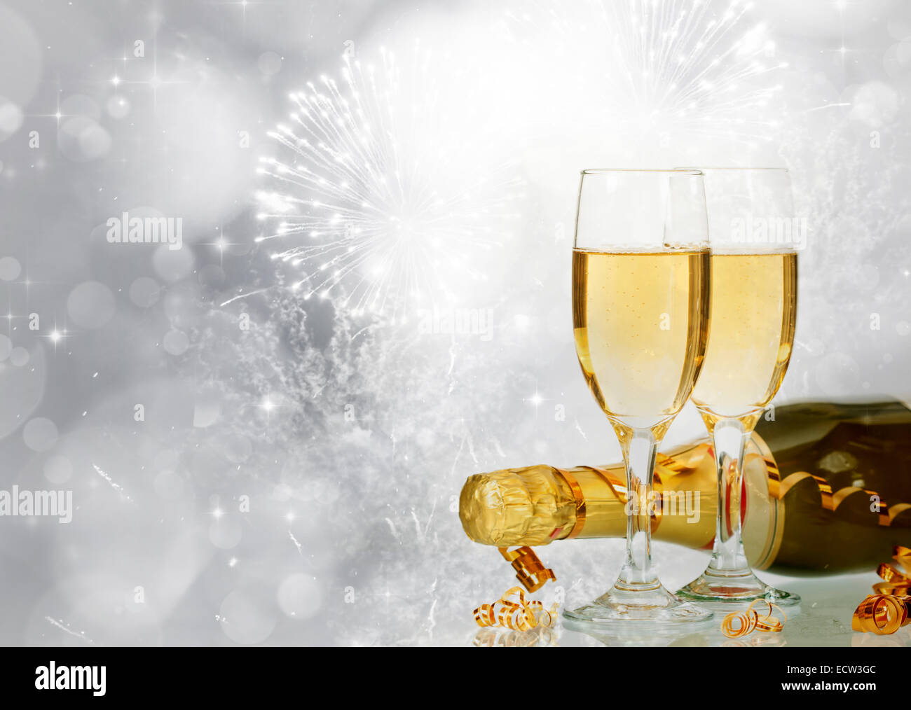 Glasses with champagne and bottle over sparkling holiday background