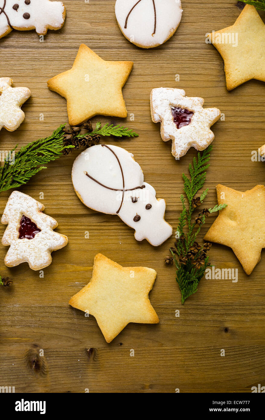Sugar cookies in shape of snowman, stars, and christmas tree on wood table. Stock Photo