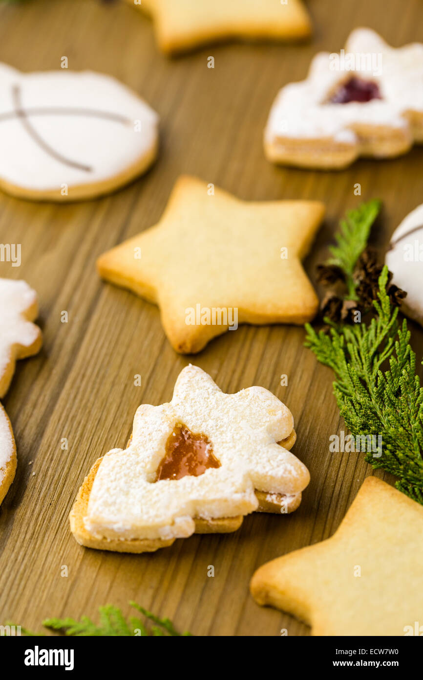 Sugar cookies in shape of snowman, stars, and christmas tree on wood table. Stock Photo