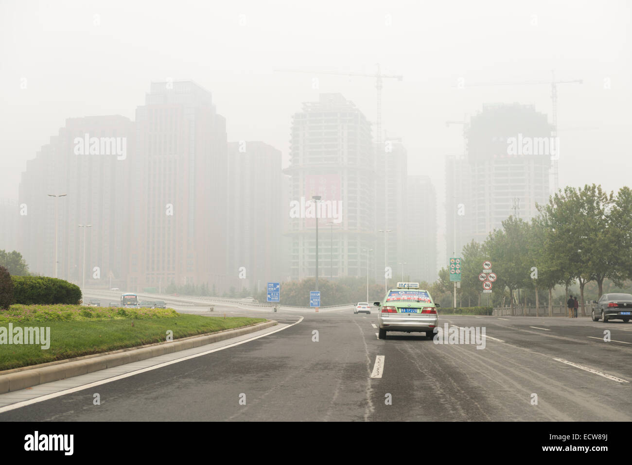 Developing city skyline covered in smog, view from a highway in ZhengZhou, Henan, China 2014 Stock Photo