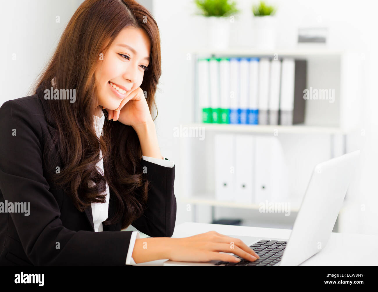 smiling young business woman working with laptop Stock Photo - Alamy