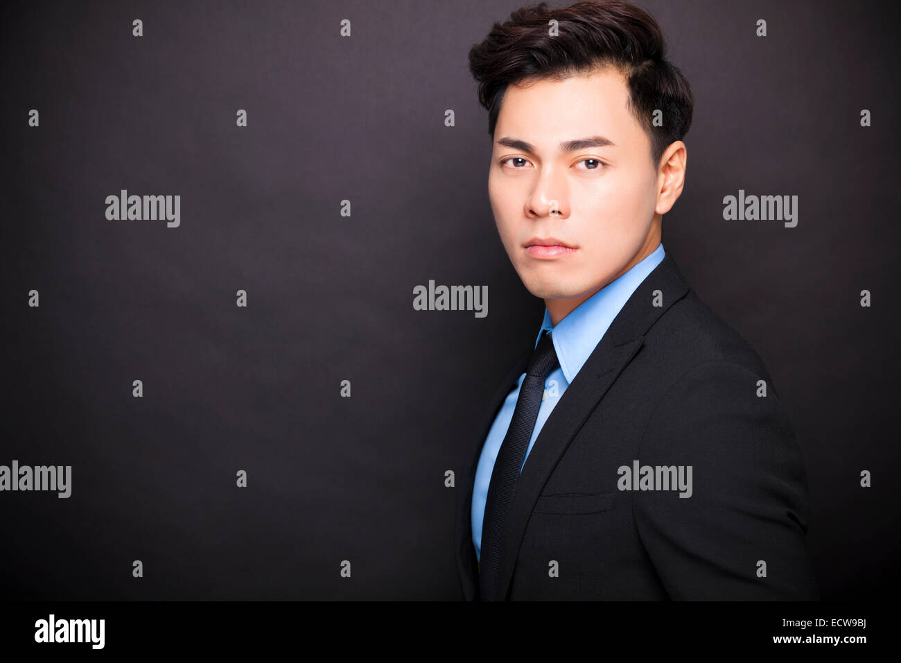 young businessman standing before black background Stock Photo