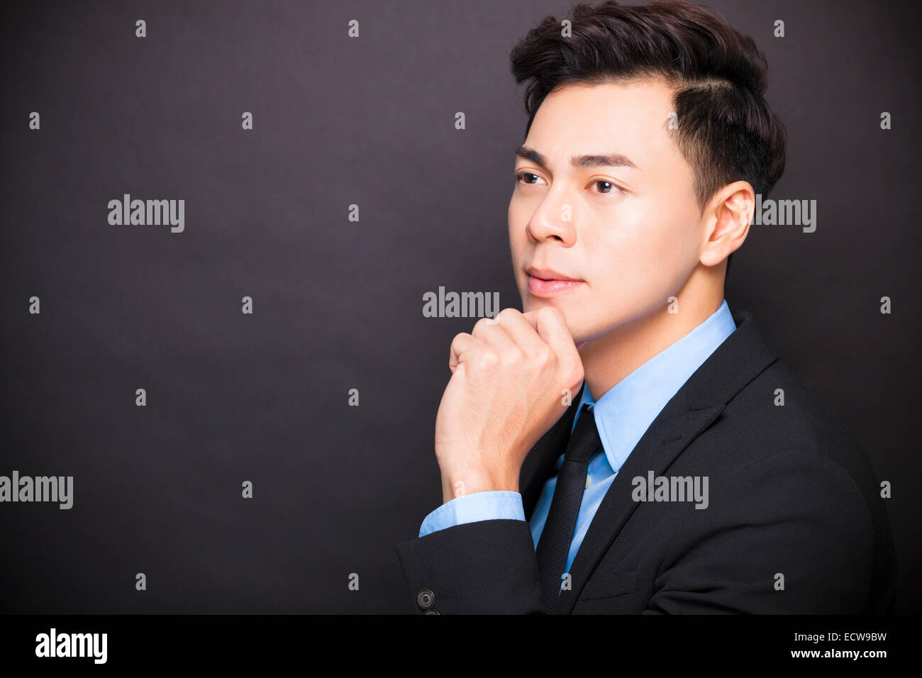 young businessman standing before black background Stock Photo