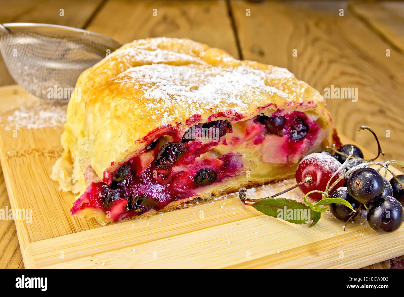 Strudel berry with strainer on board Stock Photo