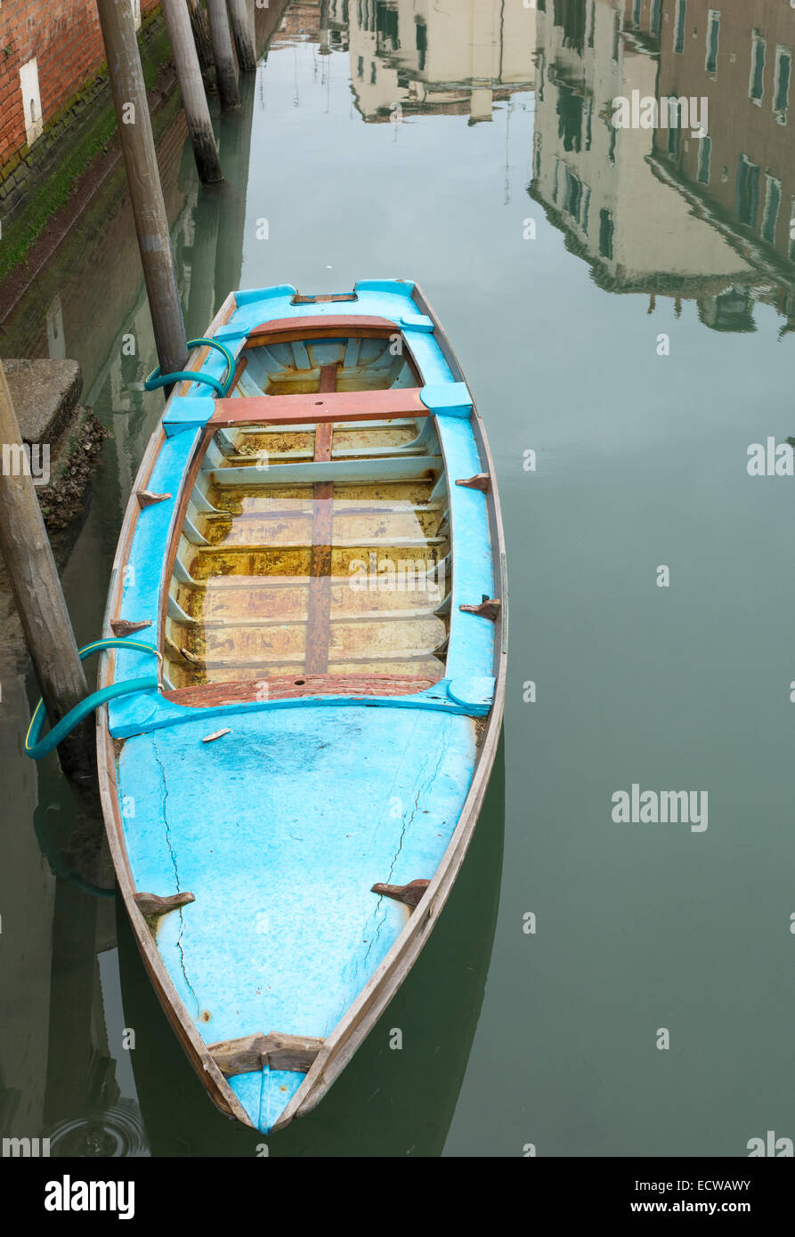 A waterlogged boat on the calm water of a canal outside the Belgian