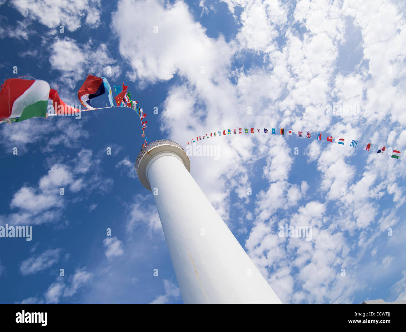 International flags fly from the Cape Zanpa Lighthouse, Yomitan, Okinawa, Japan Stock Photo