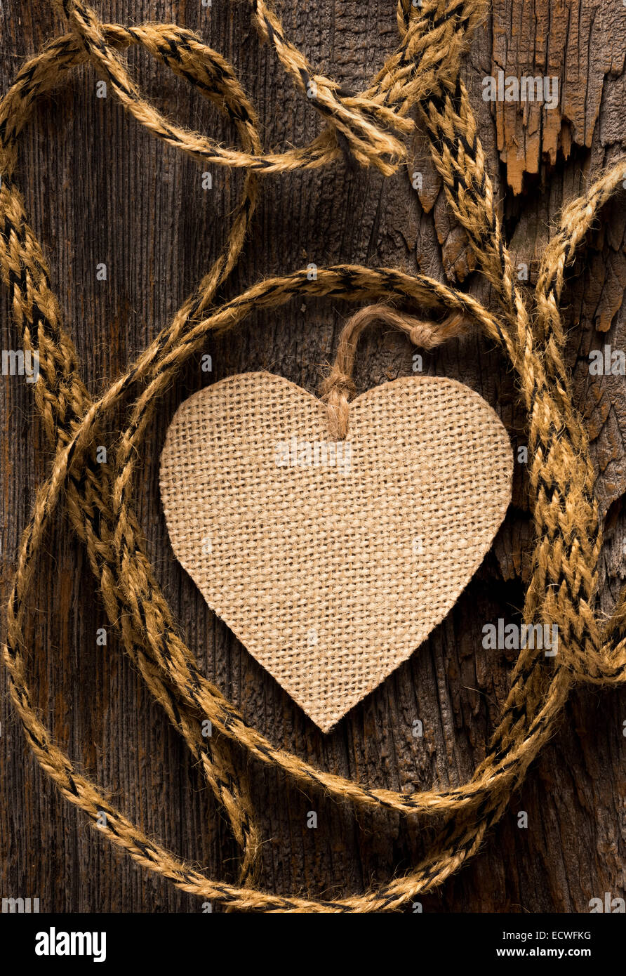 One burlap hear with coarse twine set of rustic wood Stock Photo