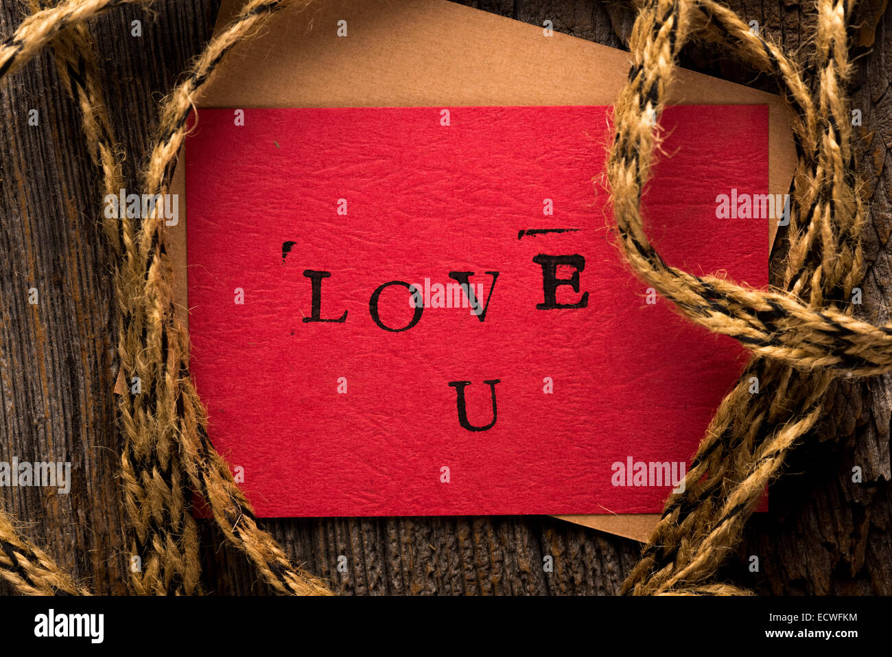 Handmade stamped valentine's day card with Love U stamped on it set on rustic wood wrapped with twine Stock Photo