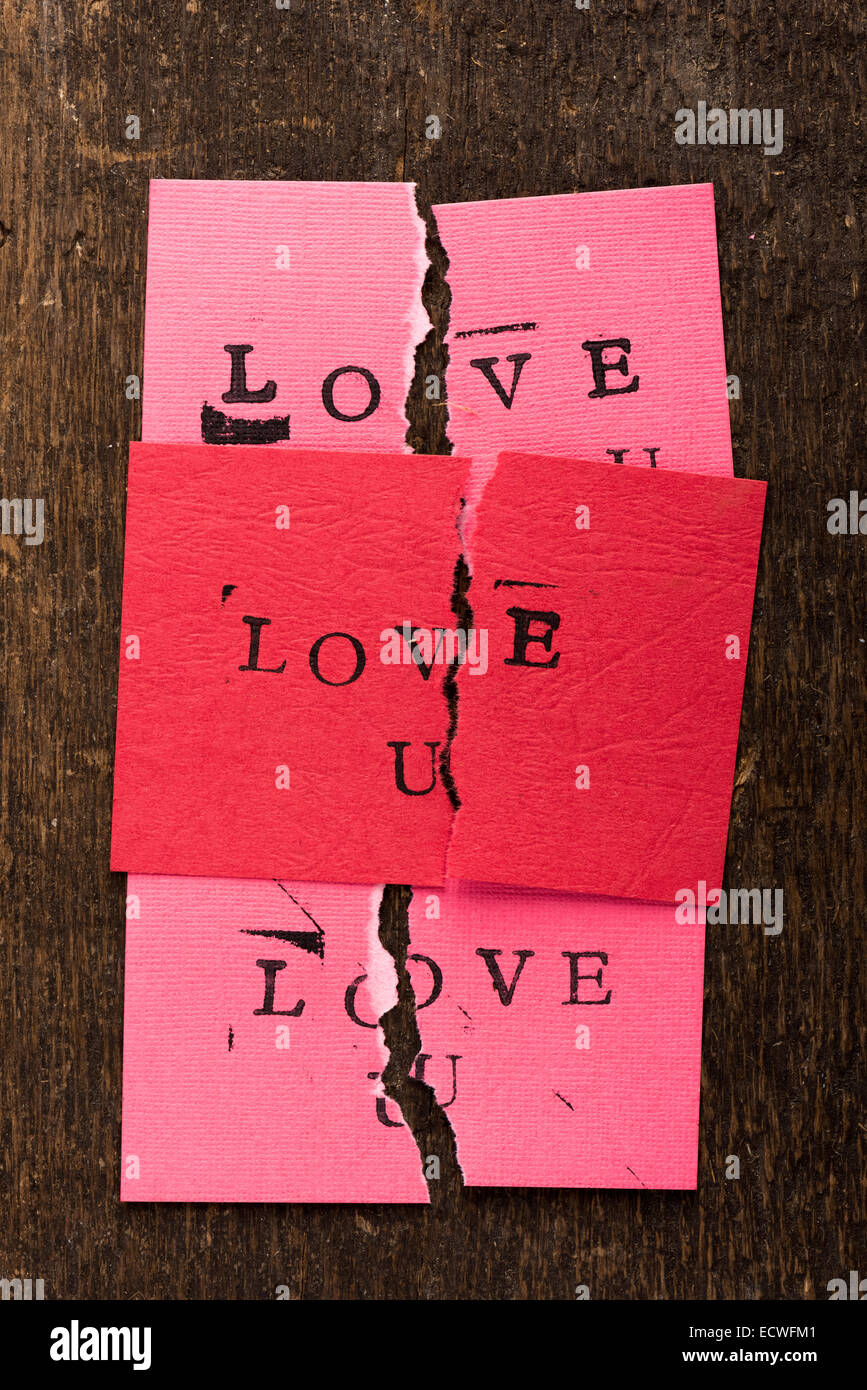 Handmade stamped valentine's day card with Love U stamped on it set on rustic wood torn in half Stock Photo