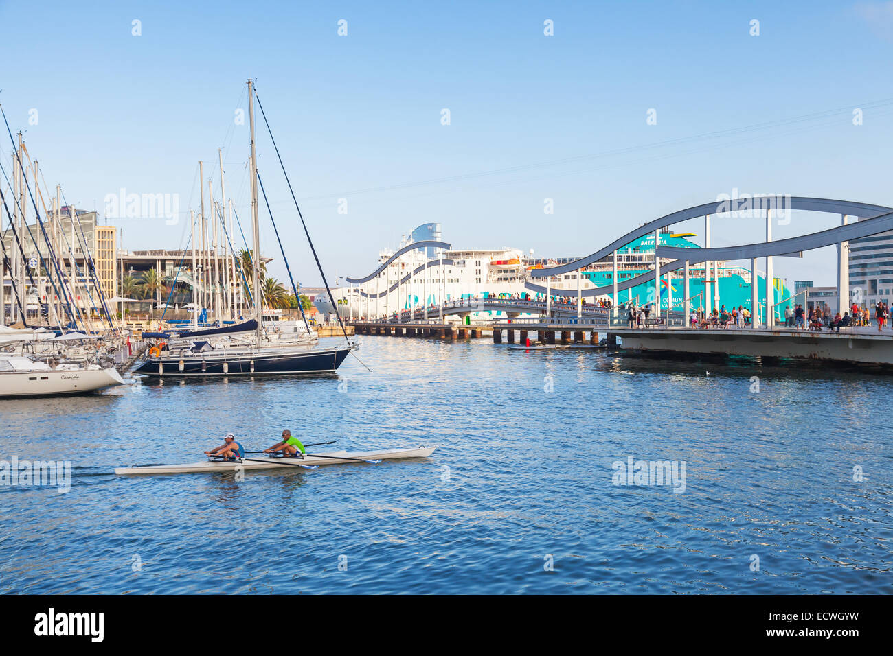 Barcelona, Spain - August 26, 2014: Twin racing rowing boat goes in Vista port harbor with walkway Bridge on a background Stock Photo