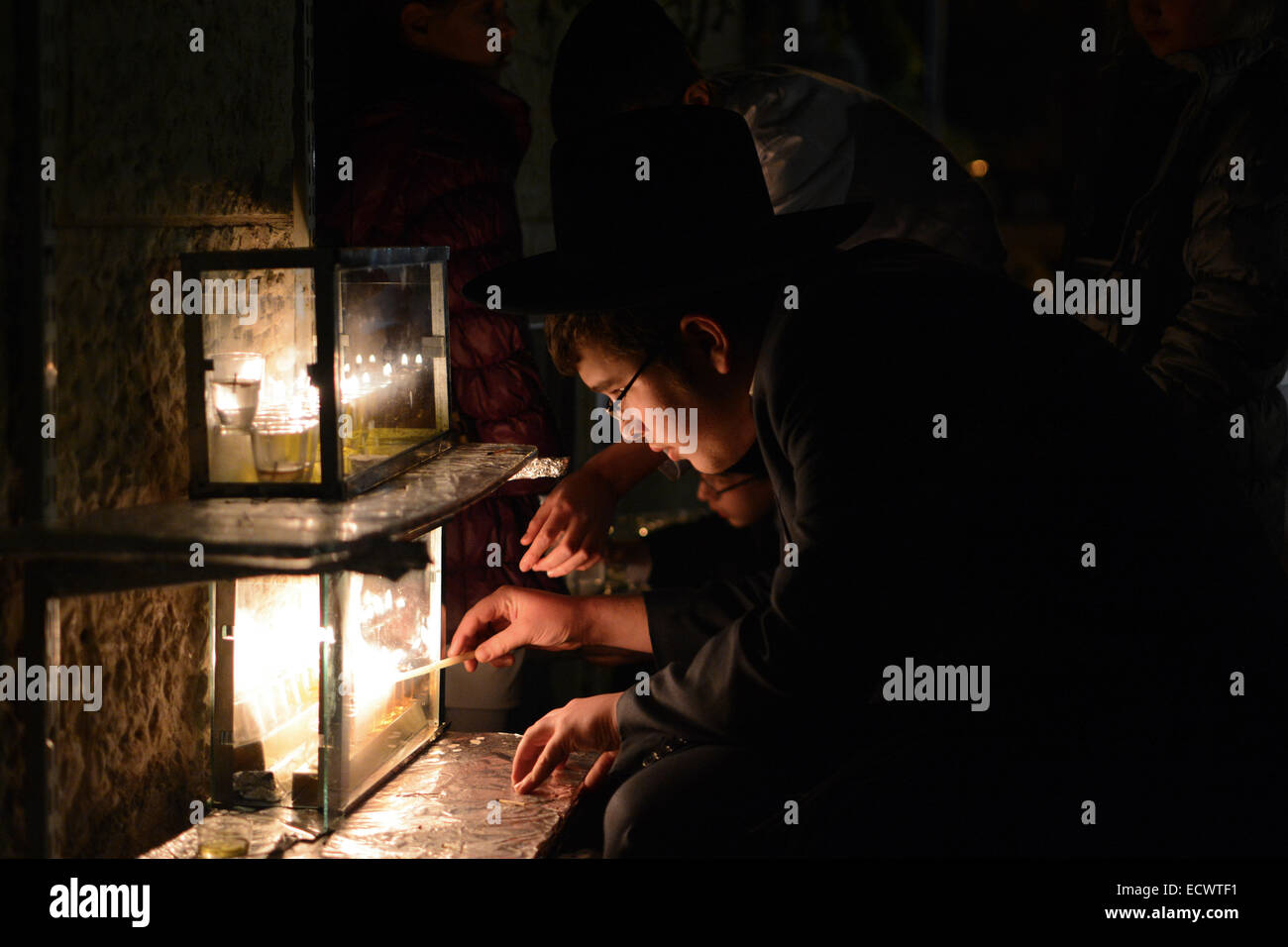 Religious Jew lighting Hanukkiah (a special candle set) during the 5th night of Hanukkah in the religious neighborhood of Nachlaot, Jerusalem. Credit:  Laura Chiesa/ Pacific Press/Alamy Live News Stock Photo
