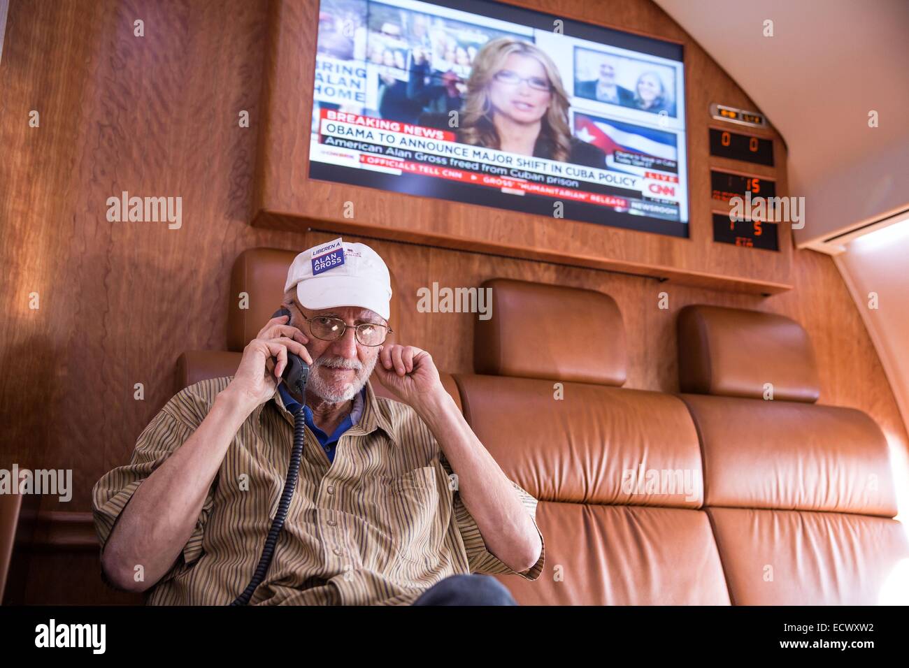 USAID contractor Alan Gross, imprisoned in Cuba for five years, speaks with President Barack Obama by phone from onboard a government plane headed back to Washington following his release December 17, 2014 near Havana, Cuba. Stock Photo