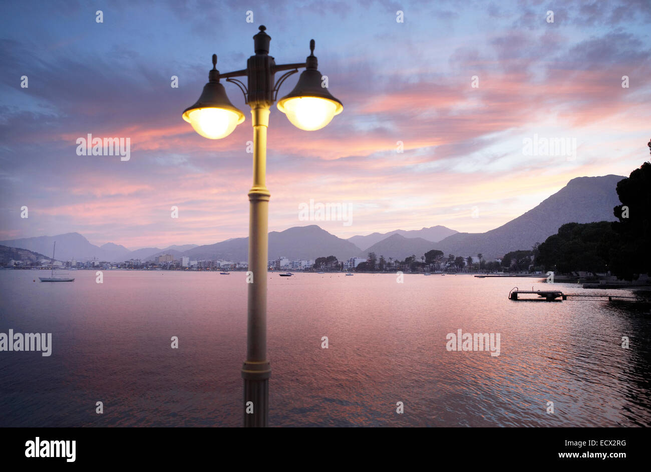 View of illuminated street light with bay and mountains in background Stock Photo