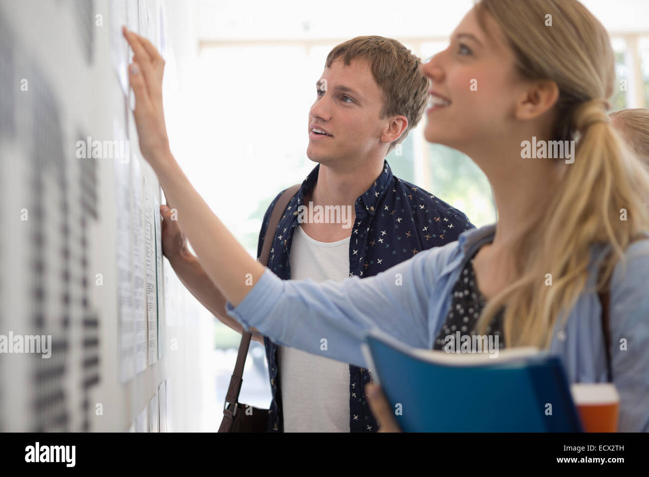 University students looking at test results in corridor Stock Photo