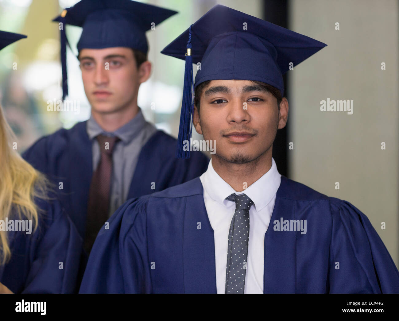 Male student in graduation clothes looking at camera Stock Photo