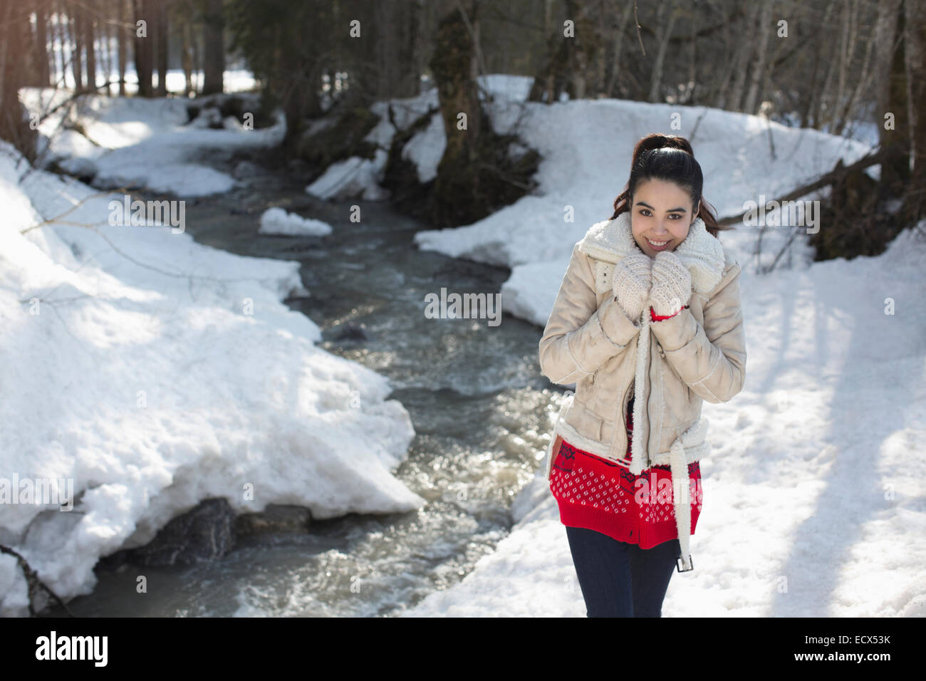 Portrait of smiling woman walking along snowy riverbank Stock Photo - Alamy