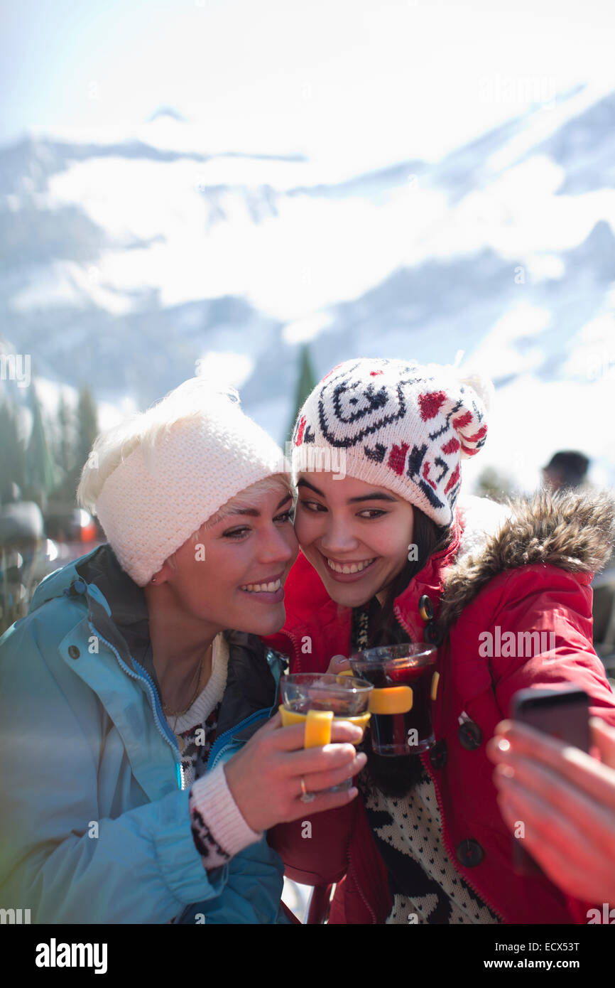 Smiling women in warm clothing drinking tea outdoors Stock Photo