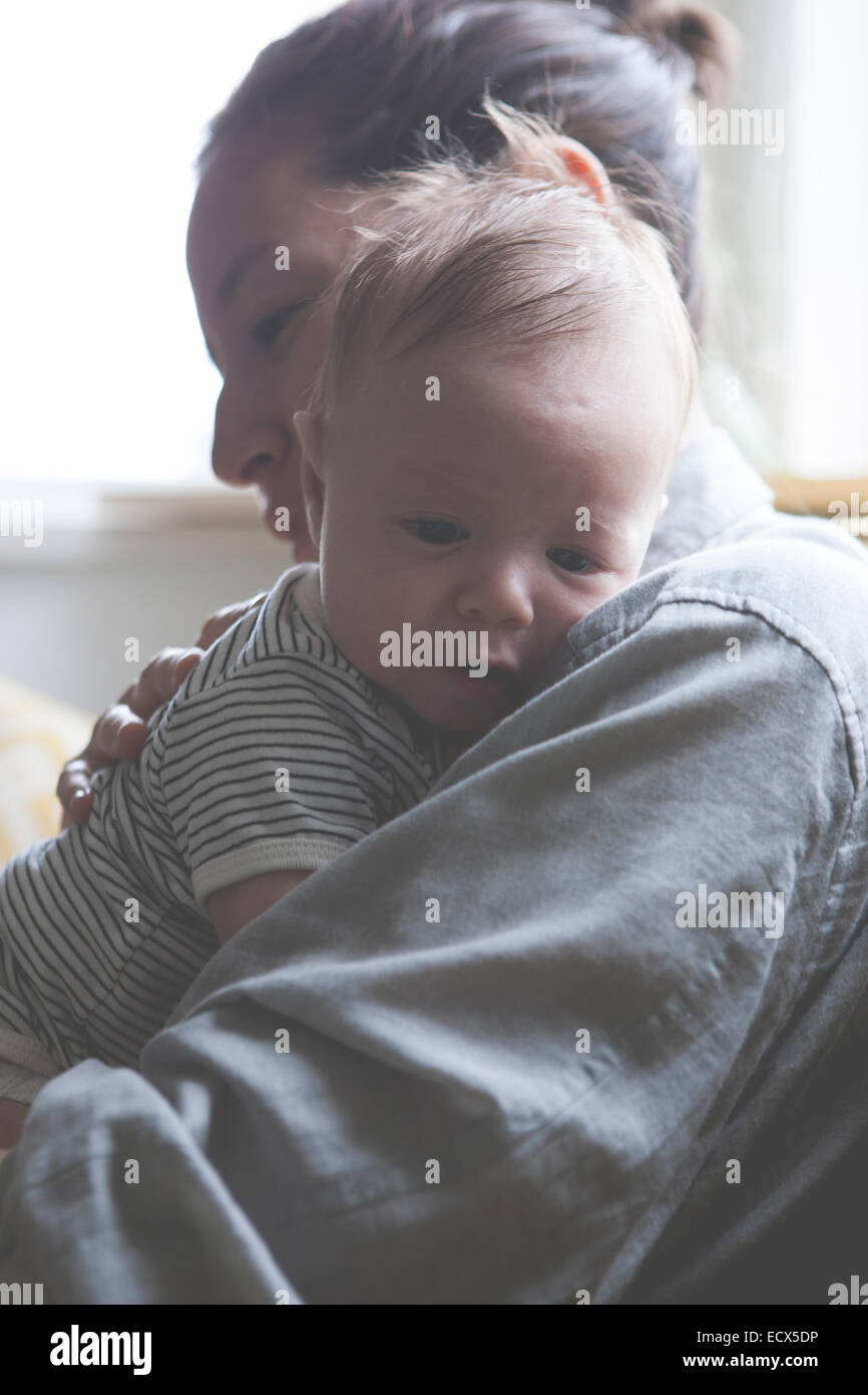 Portrait of mother holding little baby in striped t-shirt Stock Photo