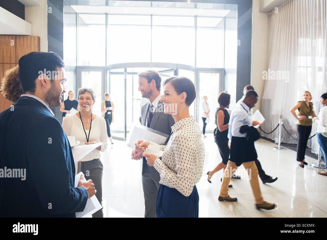 Group of business people standing and talking in office Stock Photo