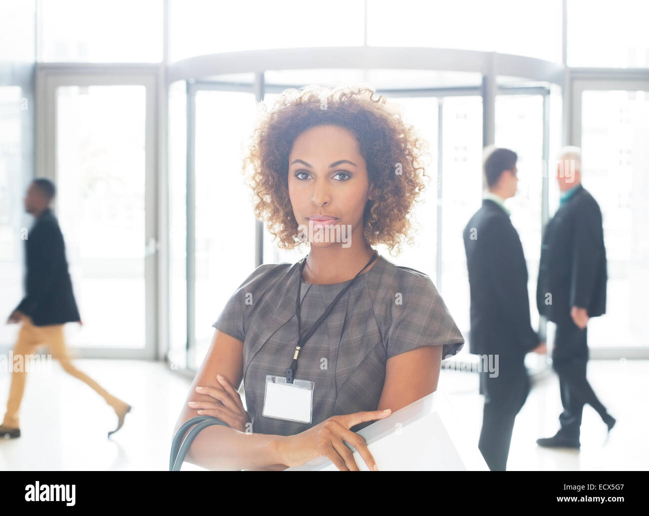 Portrait of young businesswoman with crossed arms standing in office Stock Photo