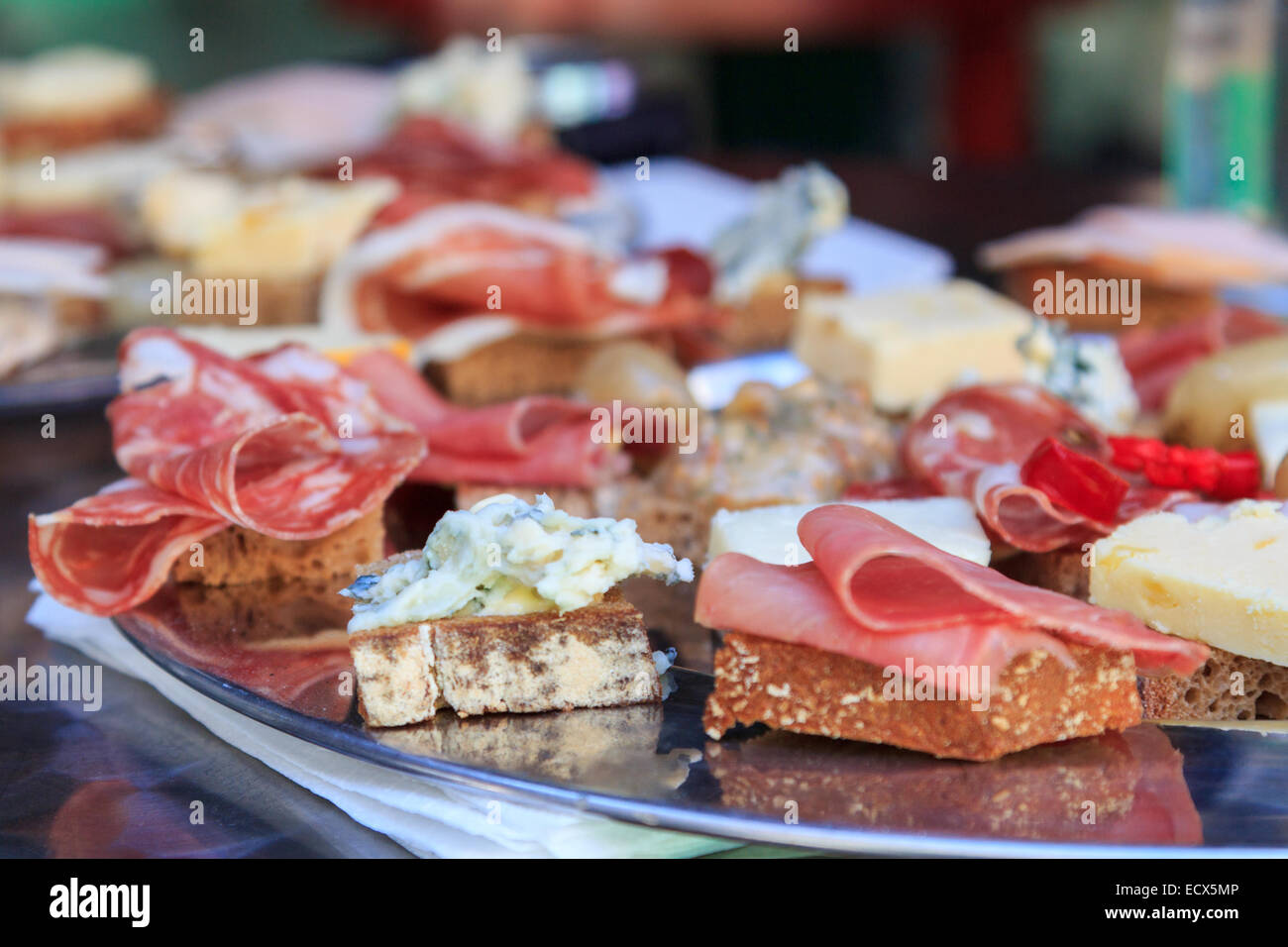 Spicy meat and cheese canapes of different types served on a silver