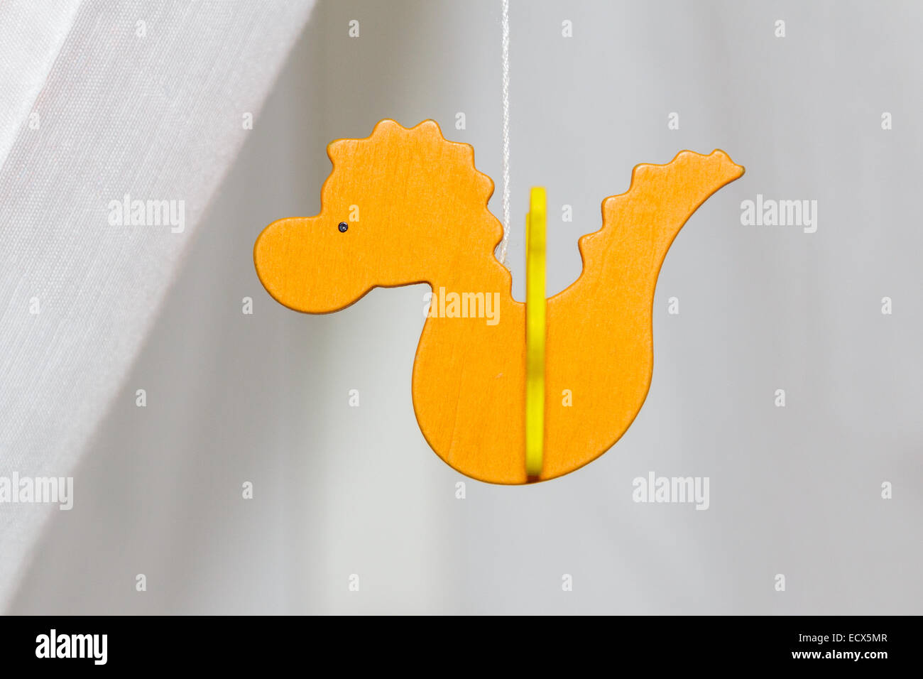 A wooden figure for a baby in the shape of an orange dragon Stock Photo